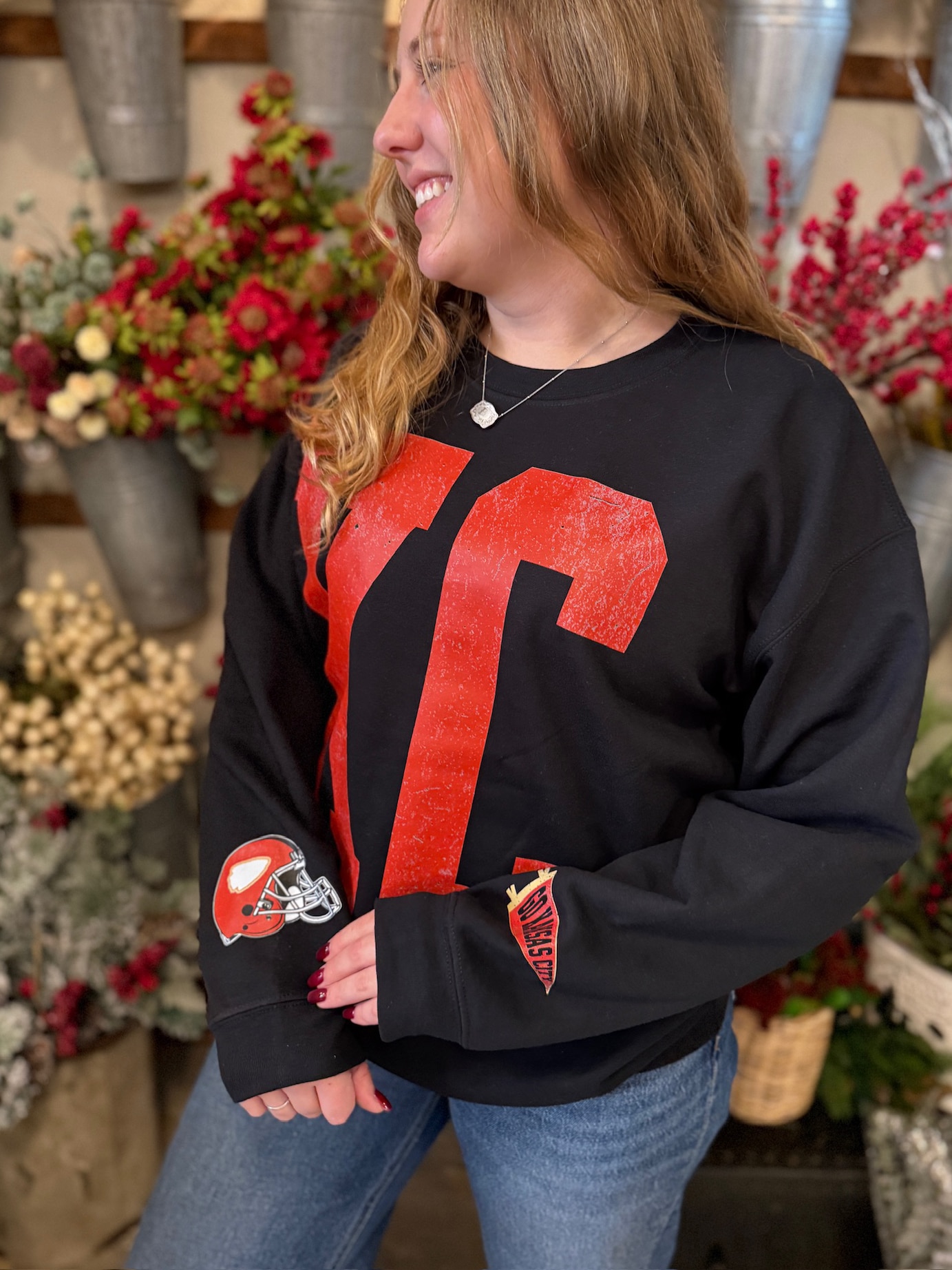 Side angle of KC crewneck featuring pennant and helmet embroidered-style sleeve patches.