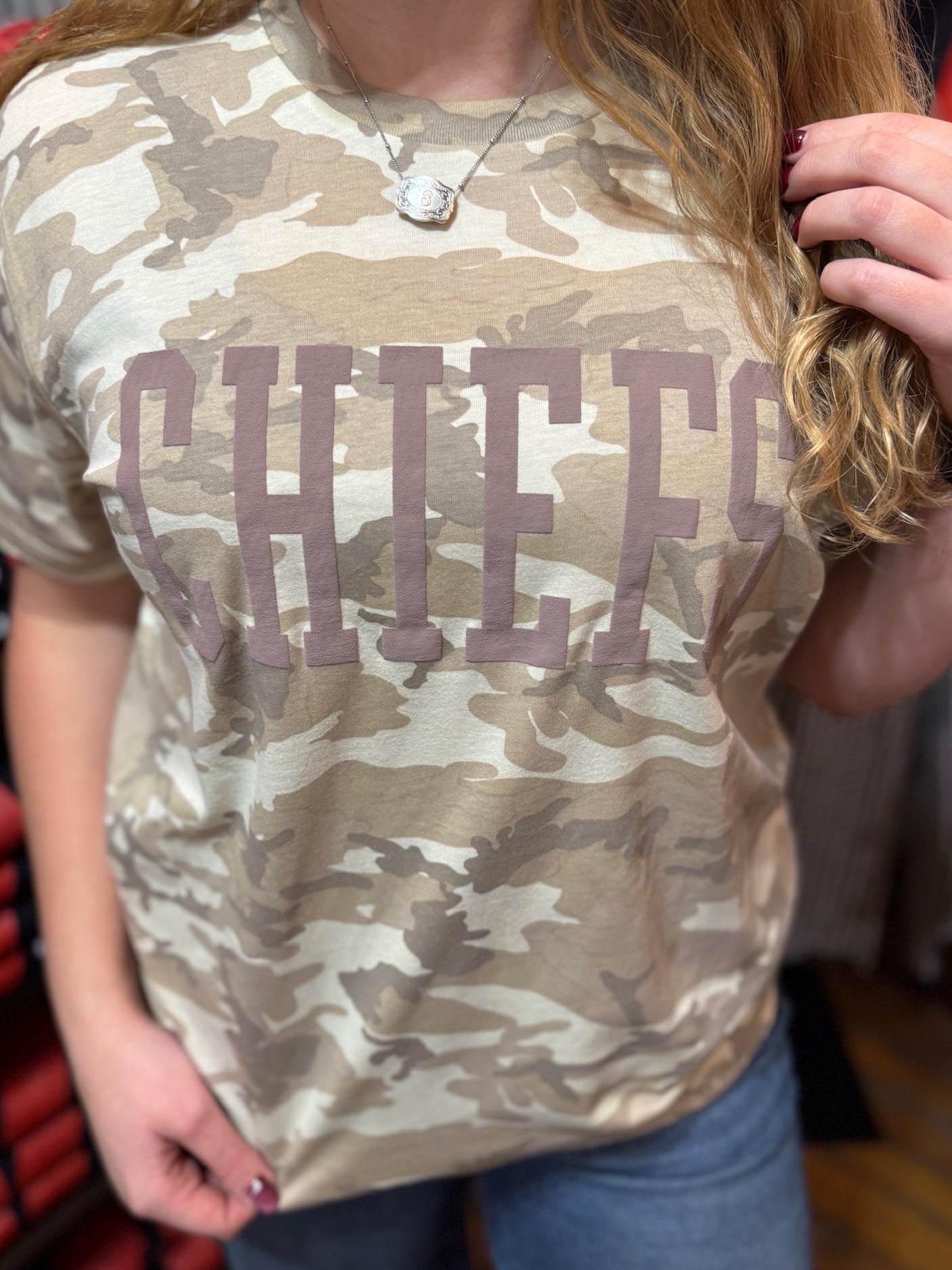 Close-up of CHIEFS puff-ink lettering on natural camo unisex graphic tee.