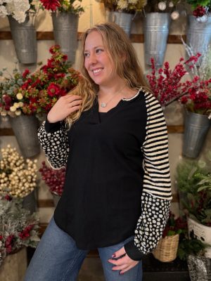 Black waffle knit pullover with mixed-pattern sleeves styled casually with denim.