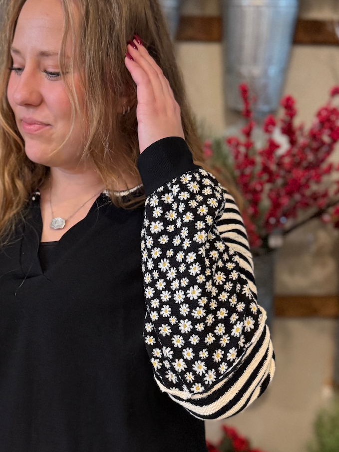 Close-up of the Waffle Knit Top in black with mixed floral and striped contrast sleeves.