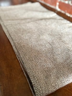 Brown & Cream Wool Table Runner with chevron tweed pattern displayed on a wooden surface.