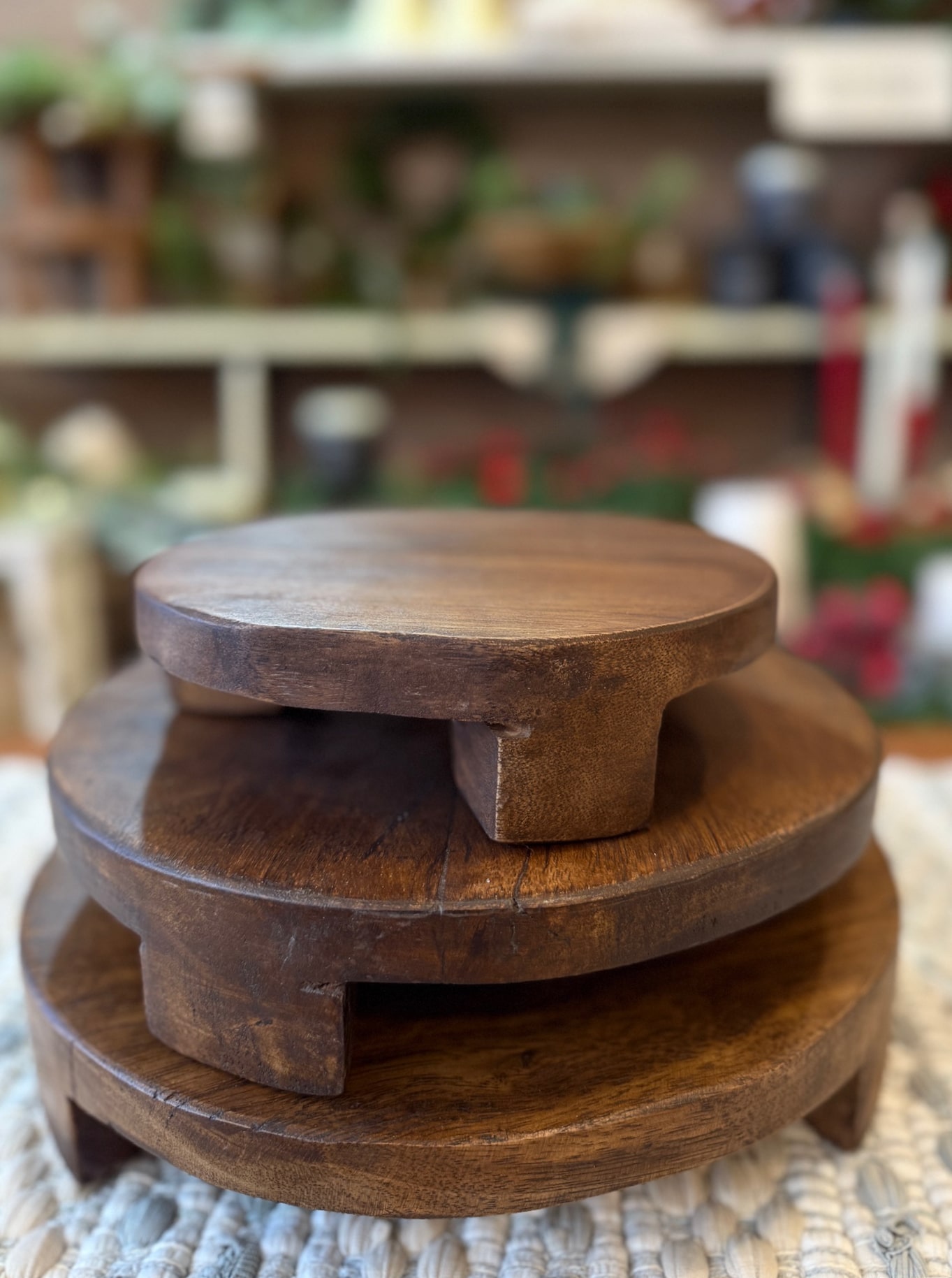 Close-up of three round found wood pedestals layered together with visible grain and natural imperfections.