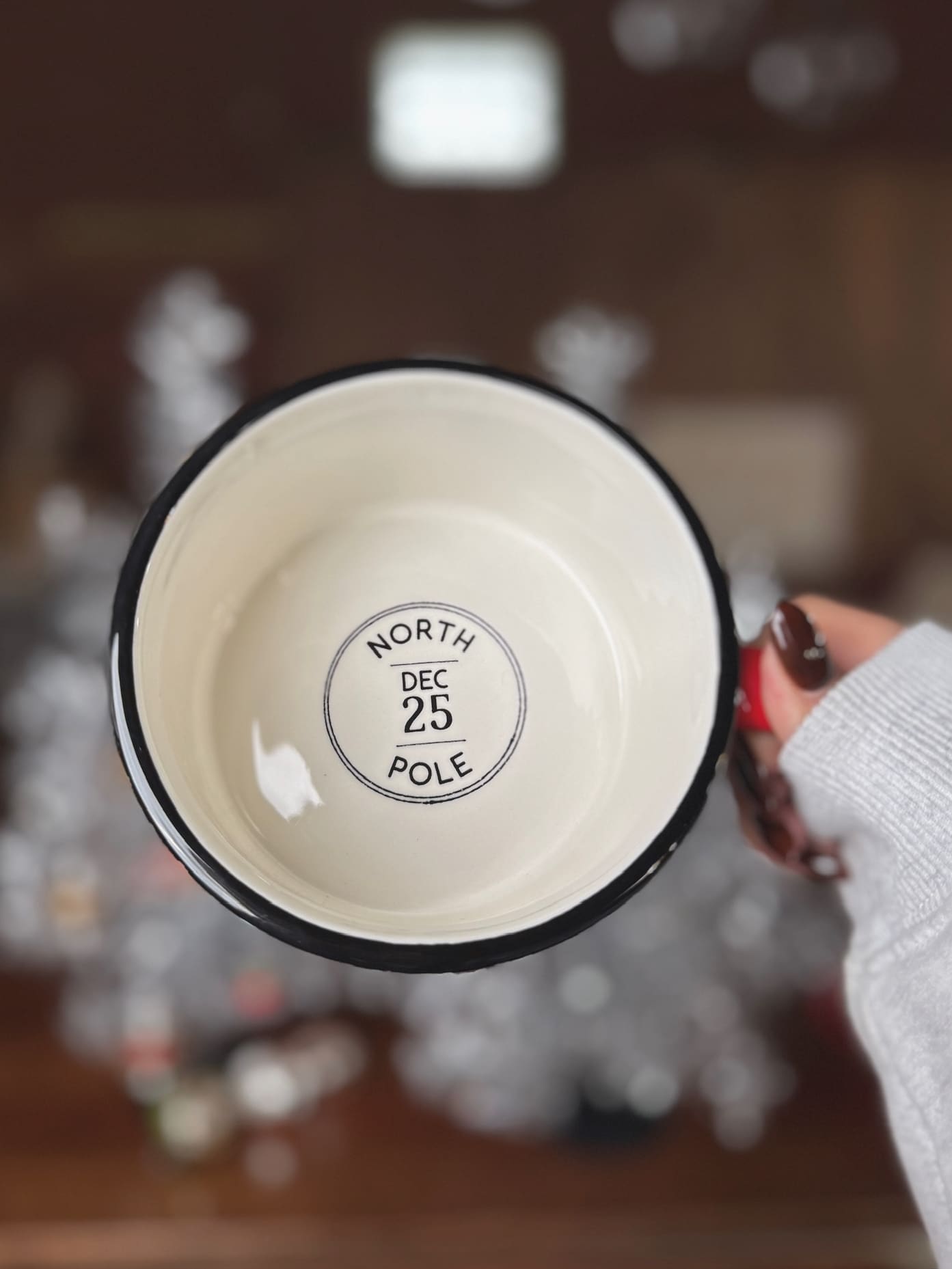 Christmas Plaid North Pole Mug tilted to reveal interior “North Pole – Dec 25” stamp with black rim detail.