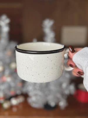 White and black speckled Hibernate ceramic soup-style mug with black rim and wide handle.