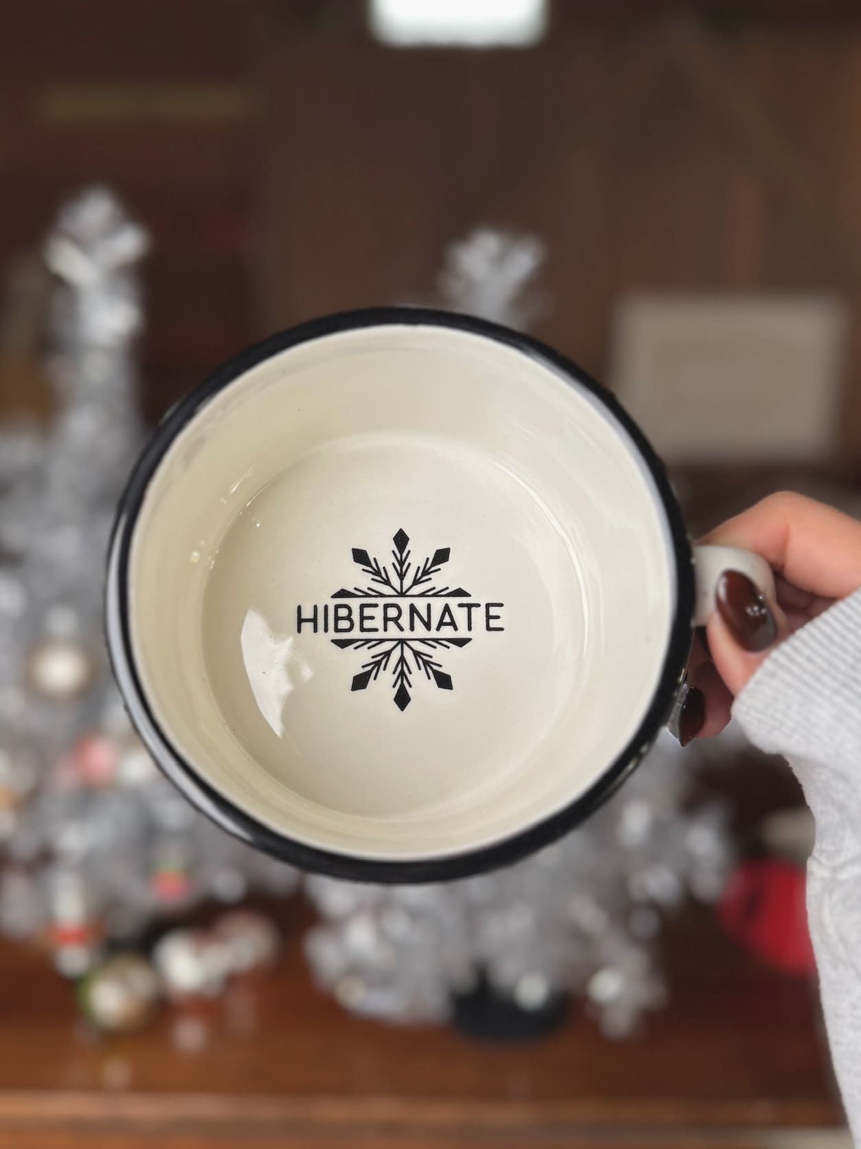 White and black speckled ceramic Hibernate mug showing interior snowflake “HIBERNATE” stamp.