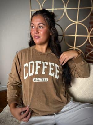 Toast tan long sleeve tee with bold Coffee Weather print, styled for casual comfort.