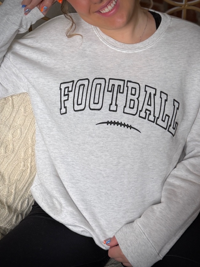Close-up of puff ink Football lettering on white heather crewneck sweatshirt