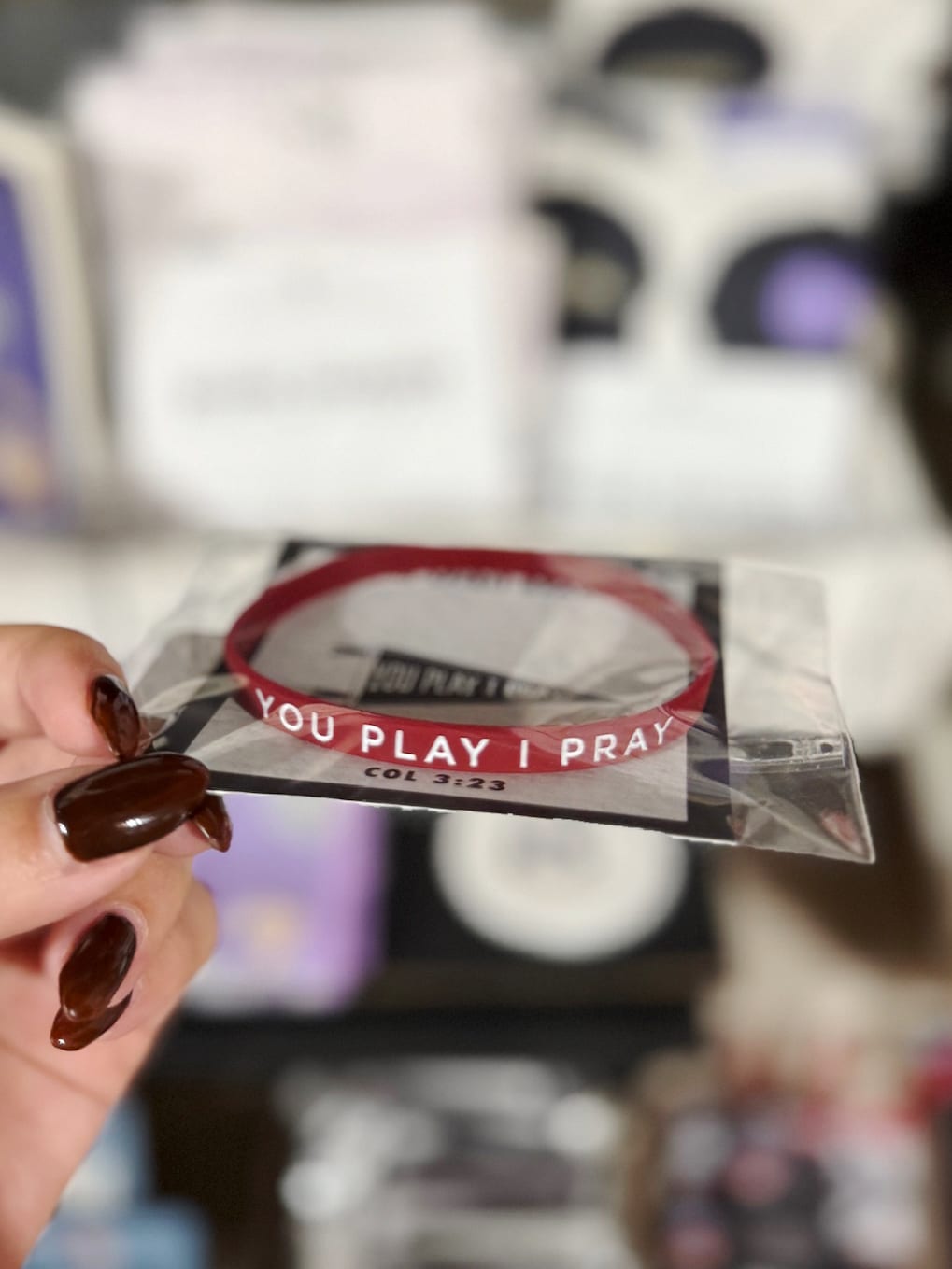 be-made-hays-ks-you-play-i-pray-bracelet-hand Maroon You Play I Pray silicone bracelet shown in hand.
