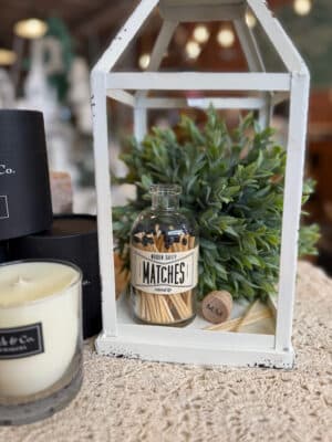 Distressed White Metal Open Frame Lantern styled with Vintage Apothecary Black Matches and greenery