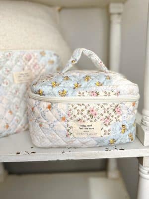 Large patchwork floral quilted makeup bag made from polyester and nylon with zippered closure and handle.