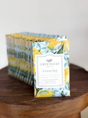 A display of Greenleaf Citron Sol Scented Mini Sachet Packets arranged in a row on a wooden table, showing their bright citrus-themed packaging.