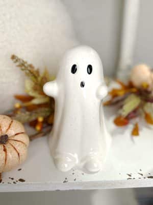 Glossy white ceramic ghost figurine with smooth glaze finish and playful design, 7 inches tall.