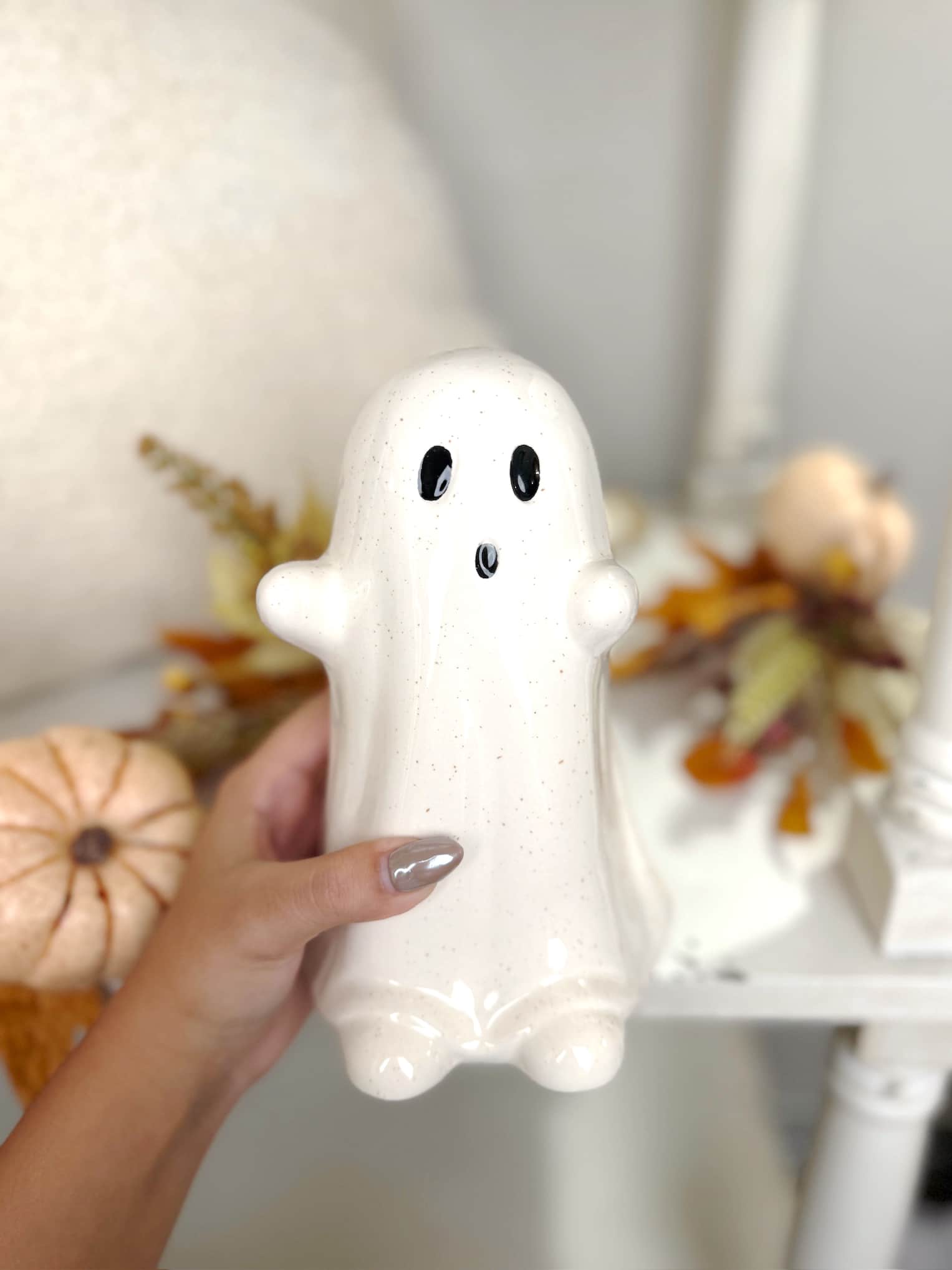 White ceramic ghost figurine with glossy glaze and wide-eyed expression, perfect for Halloween mantel or shelf decor.