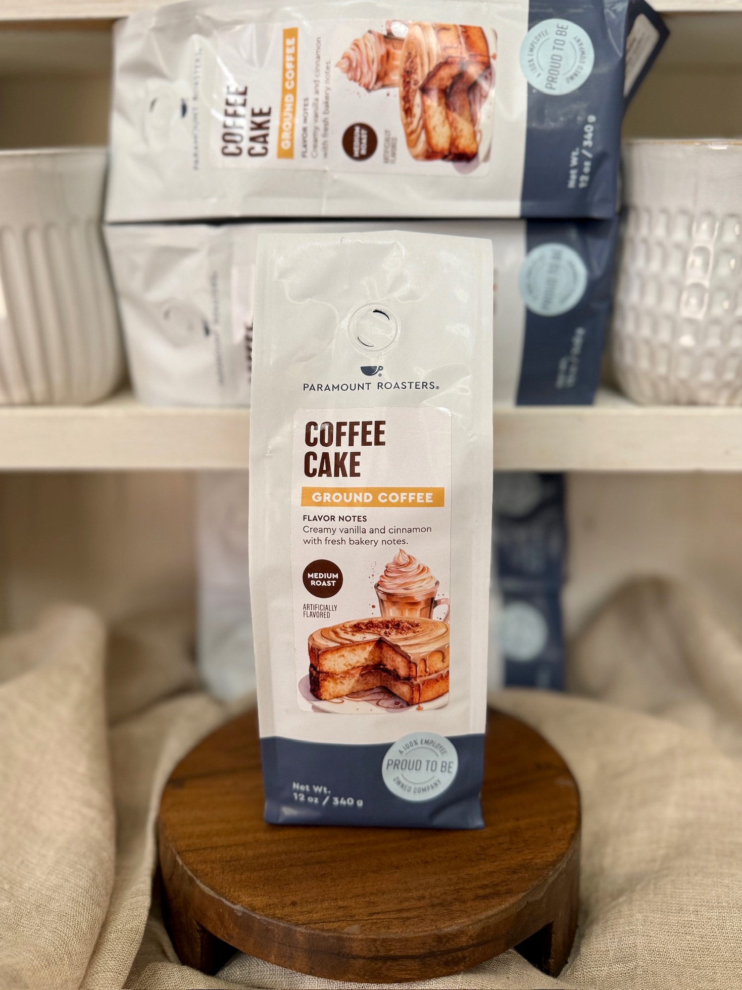 be-made-hays-ks-vanilla-cinnamon-coffee-cake-coffee-12oz Coffee Cake ground coffee packaging by Paramount Roasters displayed on shelf.
