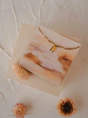 Close-up of Pray Big Mini Tag Necklace displayed on scripture card