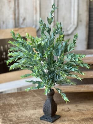 Powdered Lush Greenery Bush styled in a dark vase with layered soft green leaves.