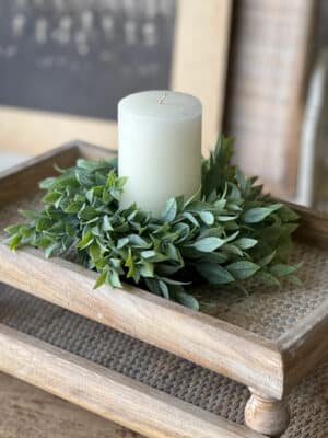 Powdered Lush Greenery Candle Ring styled around a white pillar candle on a wooden tray for a natural centerpiece look