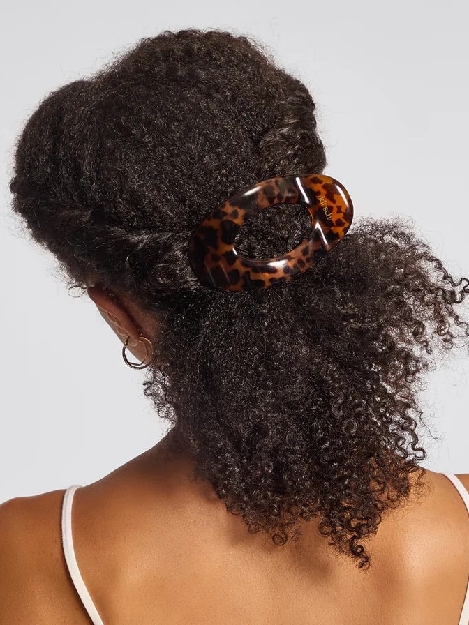 Model wearing the Flat Tortoise Cloud Clip holding curly hair in a half-up style; shows flat-back design and classic tortoise finish.
