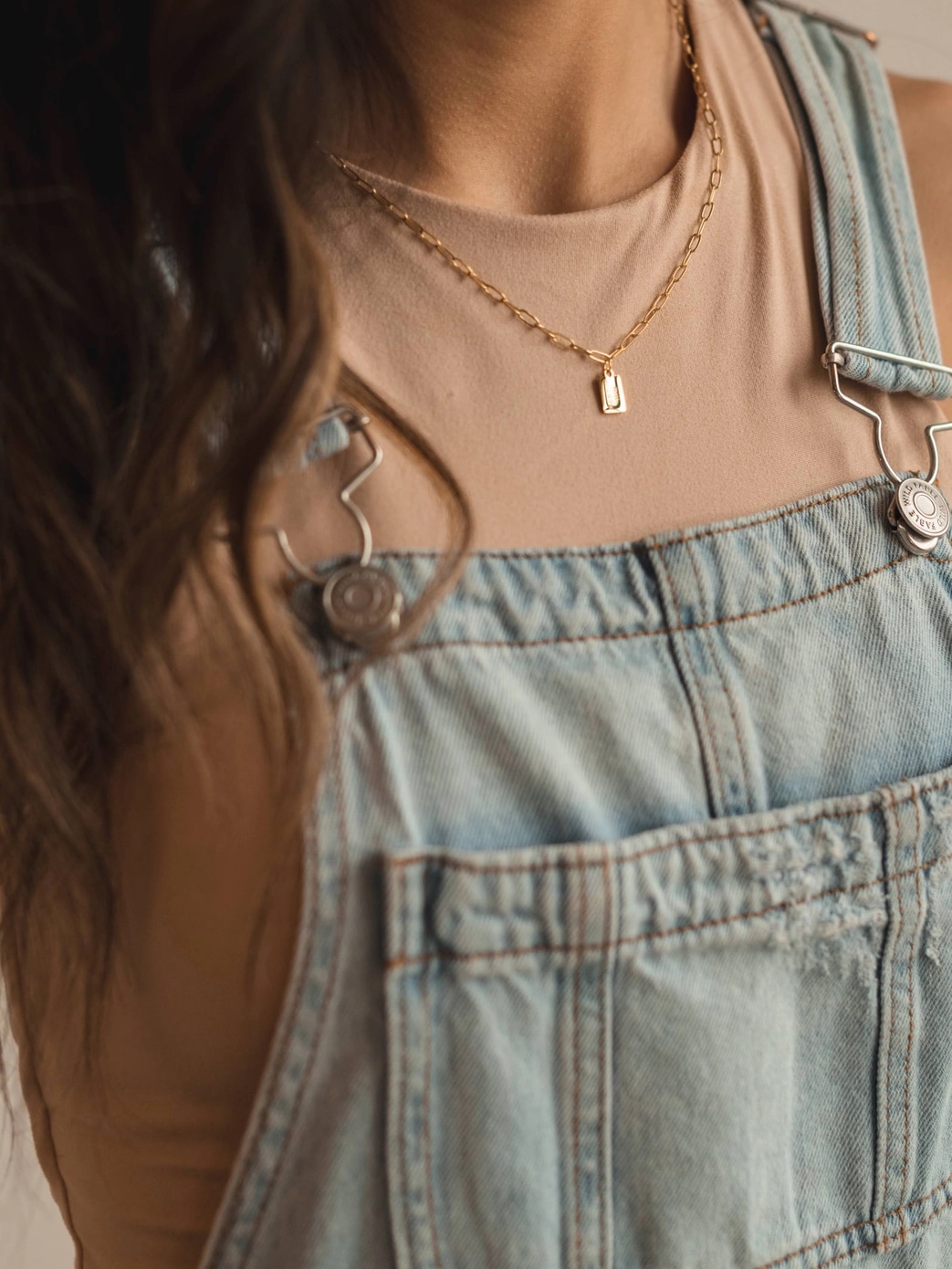 Woman wearing Rest in Him Mini Tag Necklace layered with other pieces
