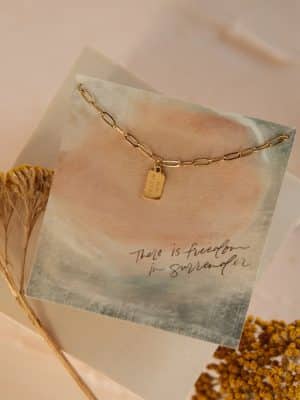 ose-up of Rest in Him Mini Tag Necklace with gold tag and chain