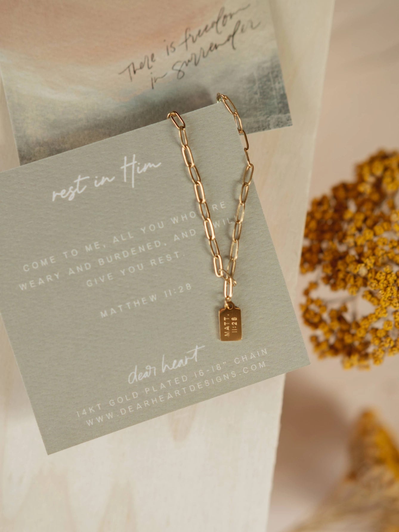 Rest in Him Mini Tag Necklace displayed on watercolor scripture card