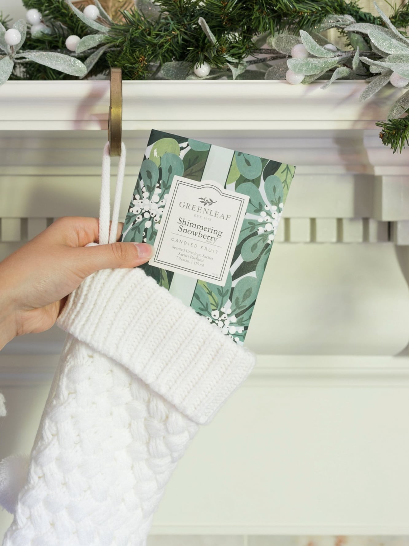 Shimmering Snowberry Scented Sachet Packet being tucked into a white holiday stocking.
