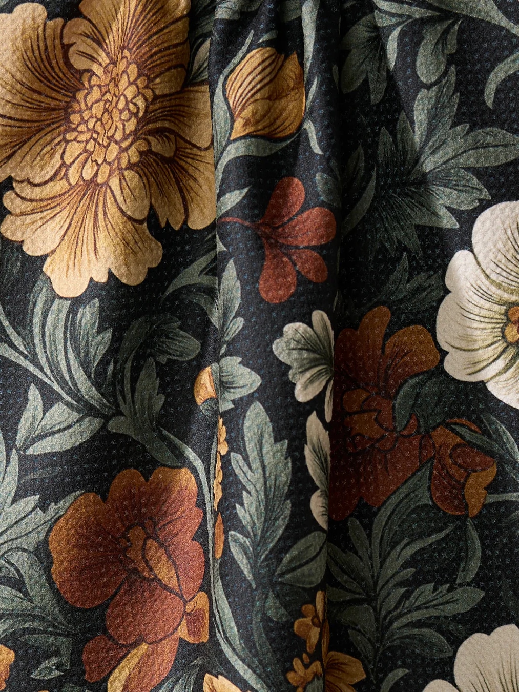 Close-up of the Classic Floral Geometry Towel showing detailed floral print in rust, tan, and white tones on black microfiber fabric.