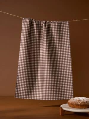 Hearth Geometry Towel with classic brown and ivory check pattern, hanging in a cozy kitchen setting.