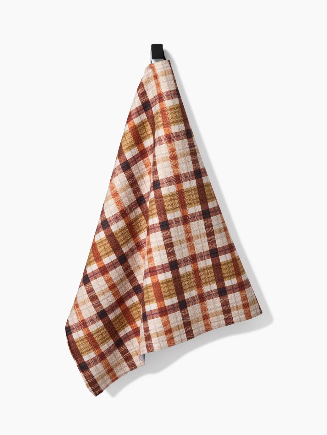 Maple Jane Geometry Towel with rust, orange, and brown plaid pattern on a cream background, hanging neatly from a hook.