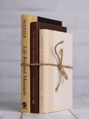 Decorative neutral book bundle in tan, brown, and cream shades with twine tie