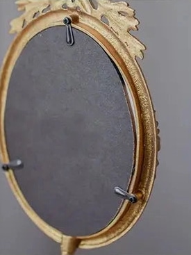 Back view of gold ornate vintage pedestal photo frame with easel stand.