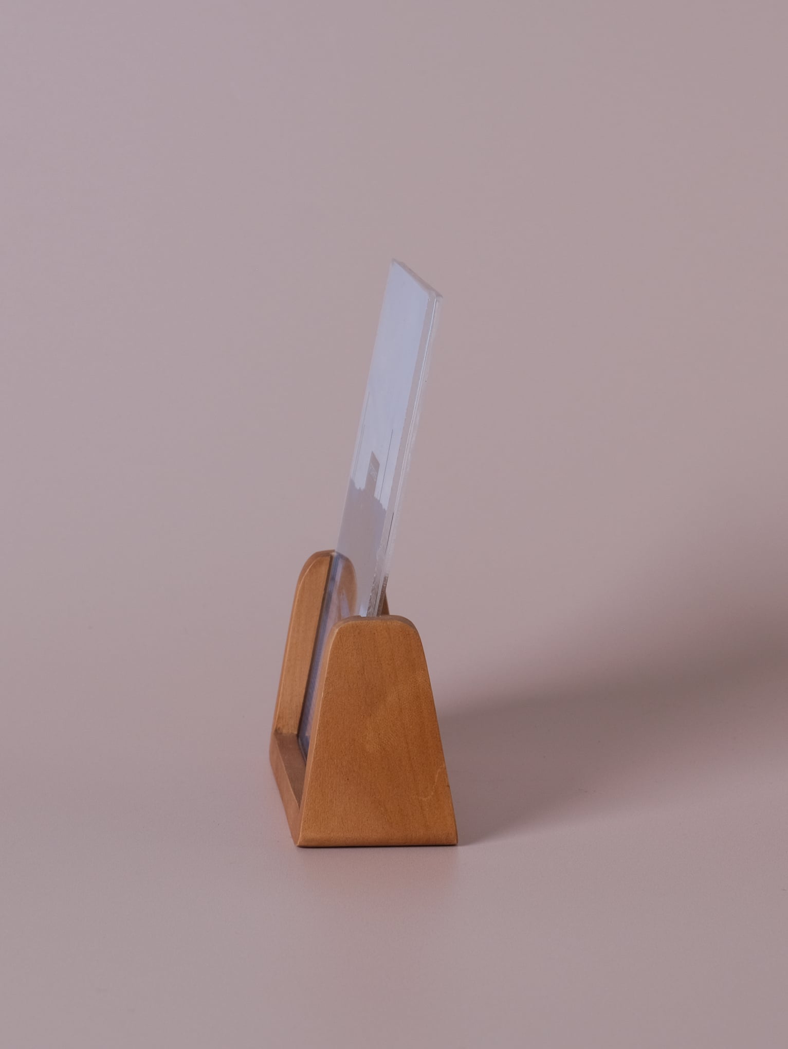 Side view of vertical wood photo frame with clear acrylic panels, showing modern U-shaped design on a neutral background.