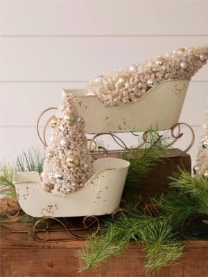 White and gold distressed sleigh with a champagne bottle-brush tree.