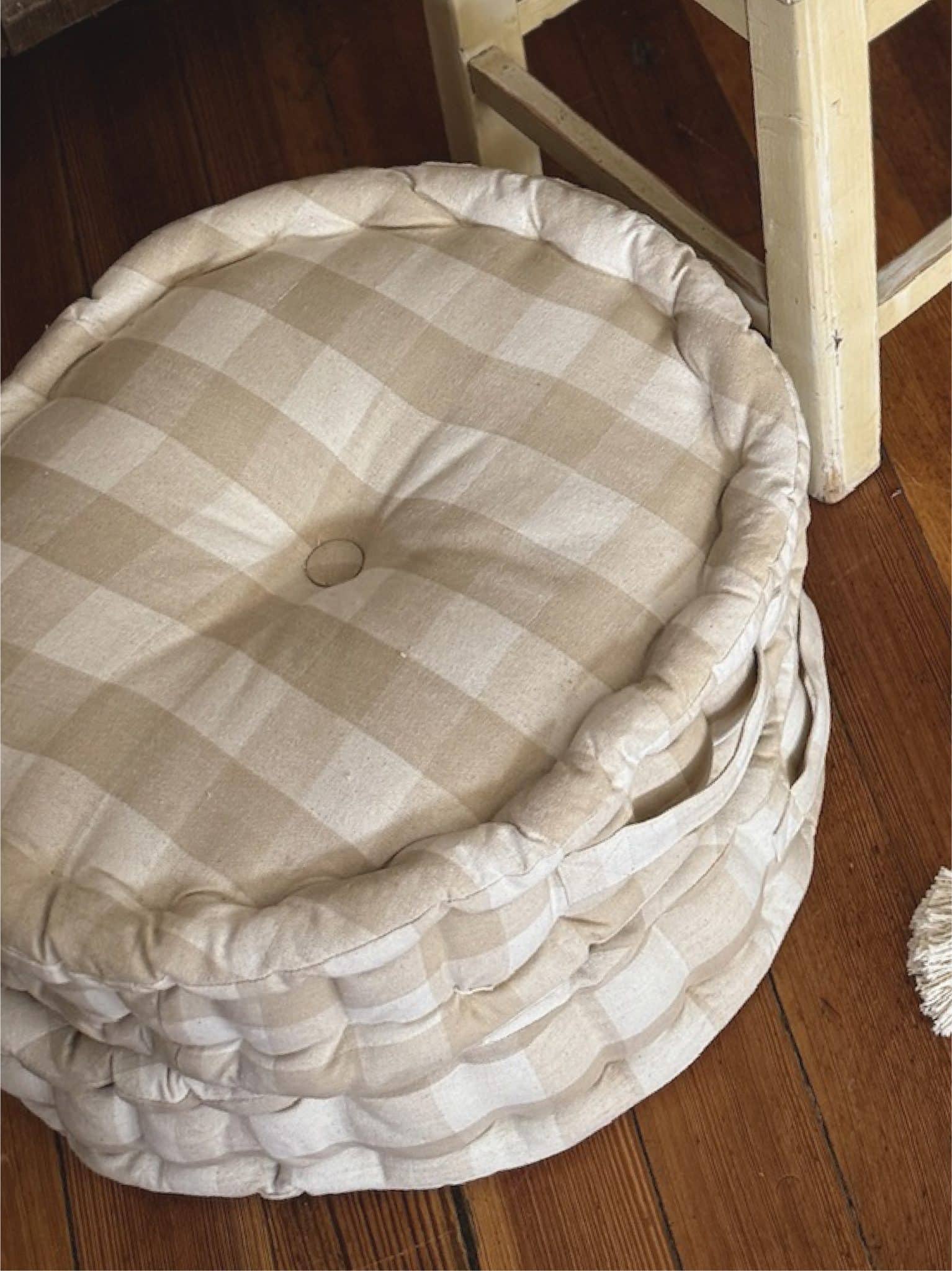 Buffalo Check Round Cushion stacked on top of each other on wood floor