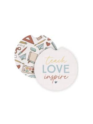 Round ceramic car coasters with colorful school supply doodles and the phrase “Teach Love Inspire,” designed to fit in standard car cup holders.
