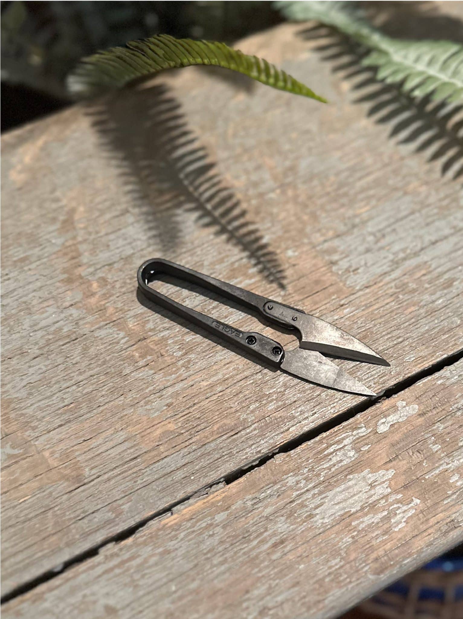 Fine Pruning Herb Snips laying down flat on wood stool