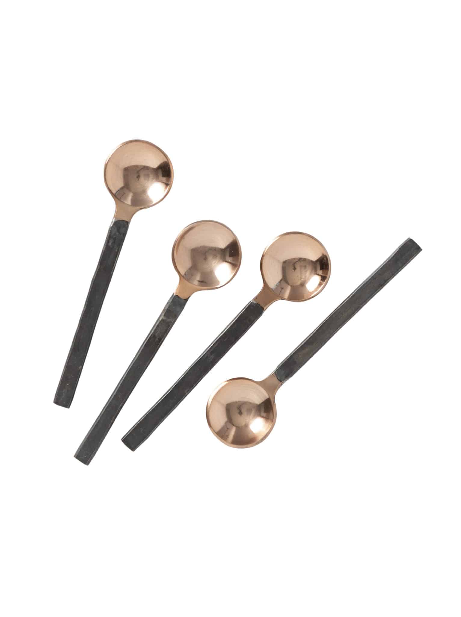 Four copper mini spoons with square black handles, arranged flat on a white background.