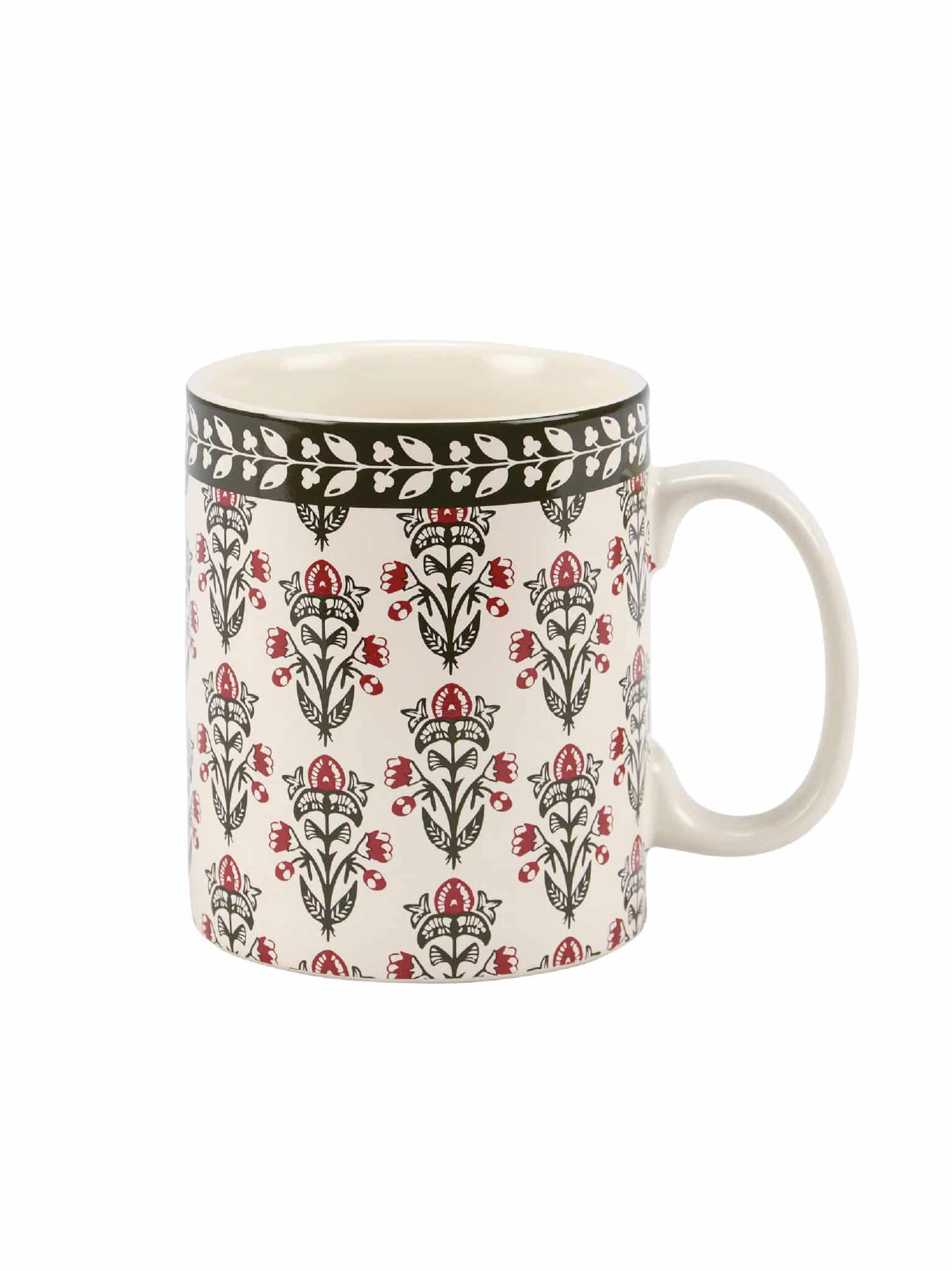 Stoneware mug with red and black floral block print and leafy rim detail.