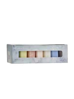 Box of seven French-milled mini soap bars in pastel shades arranged in a row