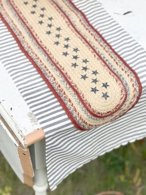 Close-up of the Stars and Striped Table Runner with red, white, and blue braided jute on striped fabric.