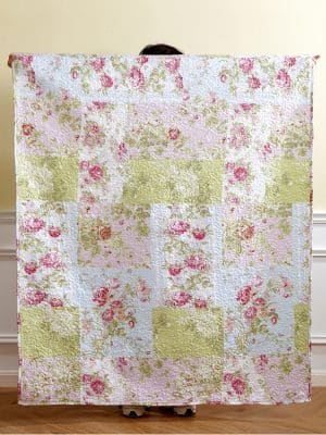 Flower Market Quilt Throw Blanket with pastel floral patchwork in pink, green, and blue