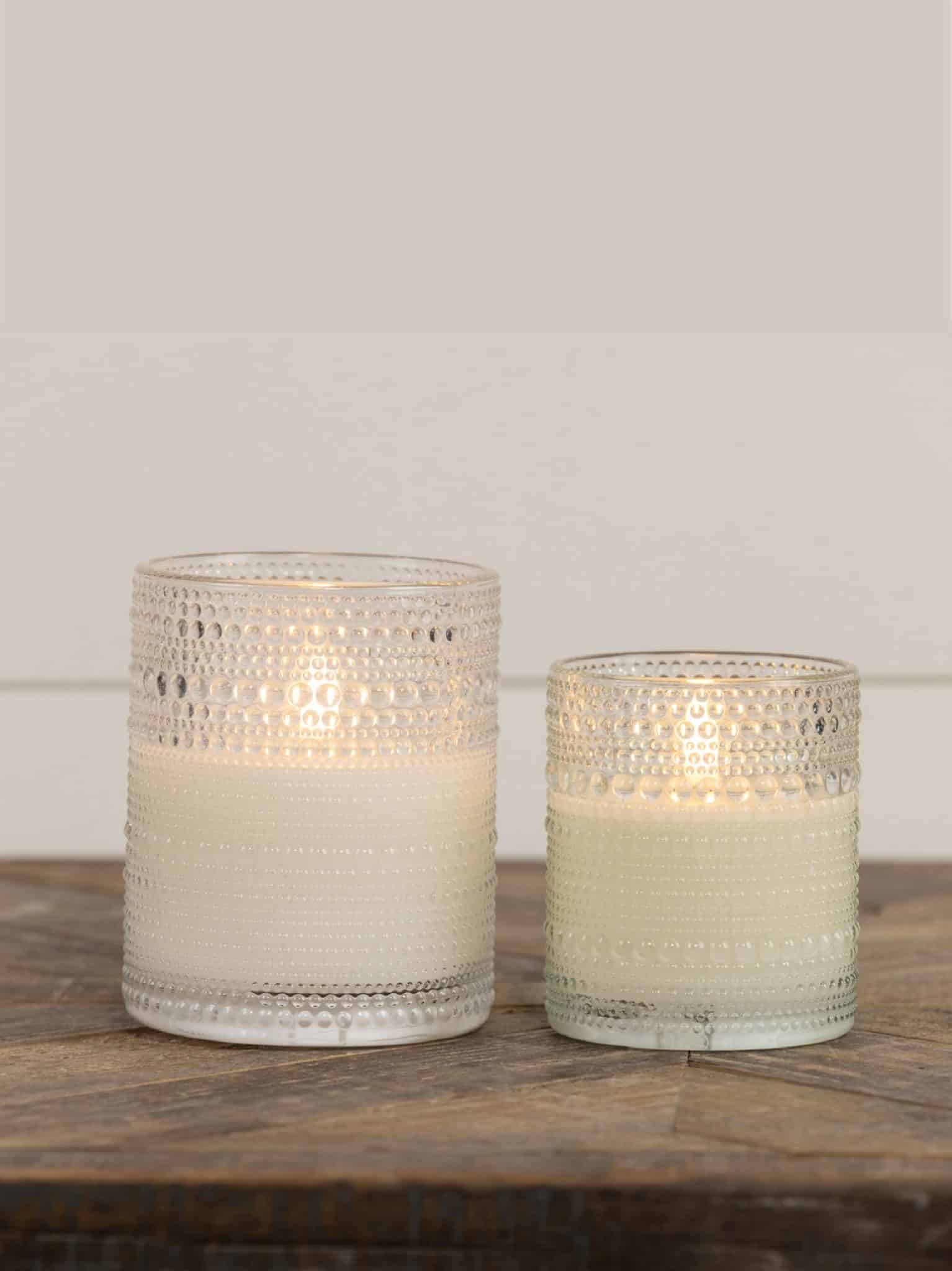 Clear Dotted Glass Flameless Candles in the 4-inch and 5-inch sizes displayed together, showing matching dotted glass design and warm glow.