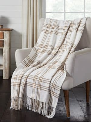 Plaid Woven Wheat Throw Blanket draped over a neutral armchair with fringe detail