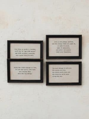 Set of four black wood framed quote signs with typewriter-style text, each featuring an inspirational saying on a neutral background.