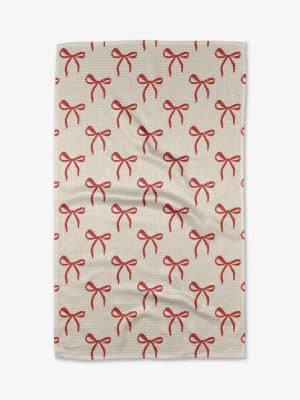 Geometry holiday towel with repeating red bow pattern on neutral background.