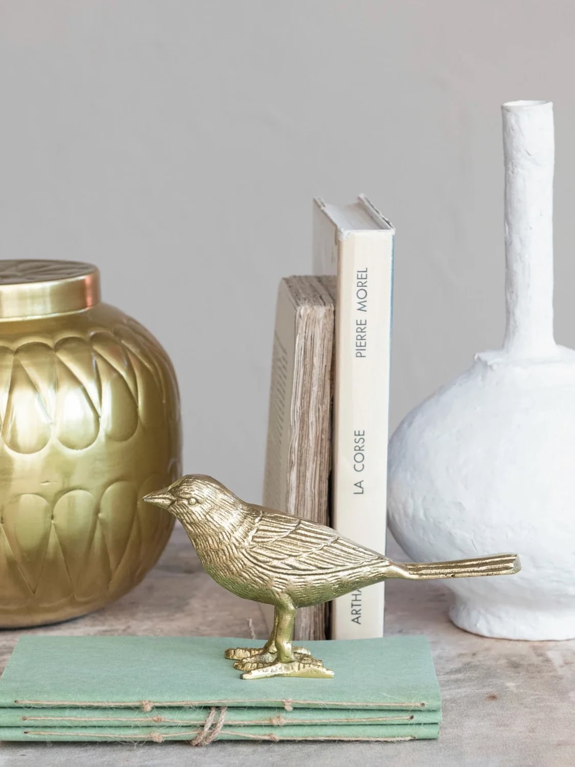 be-made-hays-ks-textured-gold-bird-figurine-styled-on-bookshelf Textured Gold Bird Figurine in gold cast aluminum styled on a shelf beside stacked books and gold and white decor accents.