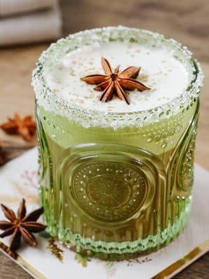 Green retro arched drinking glass filled with a creamy cocktail topped with star anise garnish.