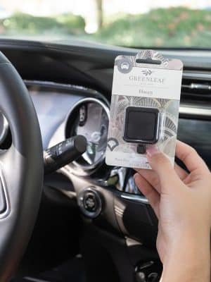 Haven Auto Vent Clip packaged, held inside car near dashboard.