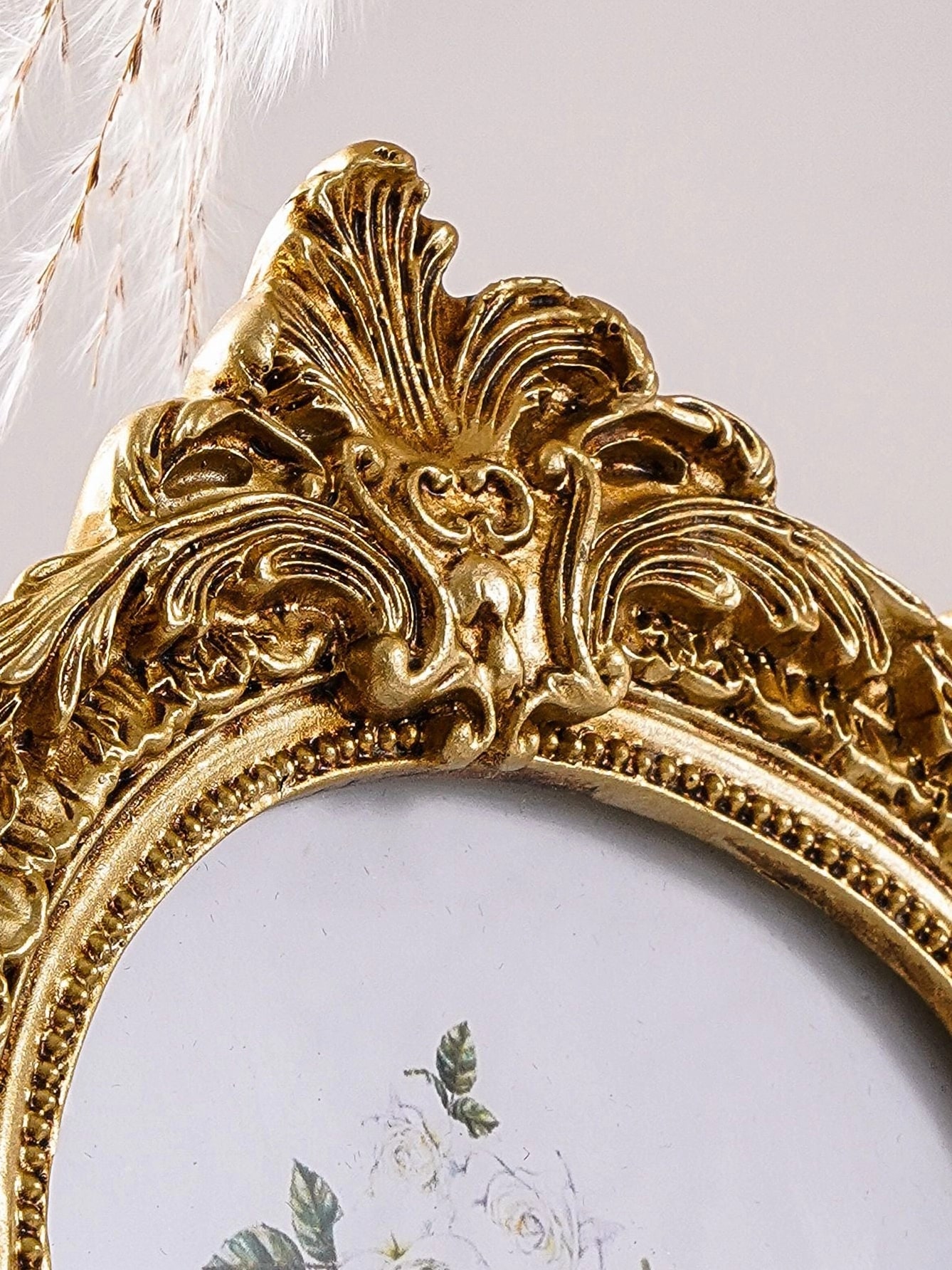 Gold ornate arch photo frame crest detail featuring decorative baroque scrollwork.