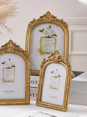 Layered gold ornate arch photo frames styled together on a tabletop for a vintage-inspired look.